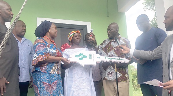 • Kwame Tenkorang (3rd from right) and Dr Mokowa Blay Adu-Gyamfi (3rd from left) presenting the keys to the house to Salormey Gyamea (middle). Looking on is Joseph Magnus Marteye (2nd from right), CEO of Joberg Foundation