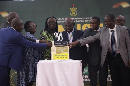Ambassador Nana Effah-Apenteng(middle), Council Chairman, KNUST, being assisted by Professor Mrs Rita Akosua Dickson (3rd left), VC, KNUST, and some other dignitaries, to cut the 10th anniversary cake of the Office of Grant and Research(OGR), during the launch of the KNUST Research Week in Kumasi.