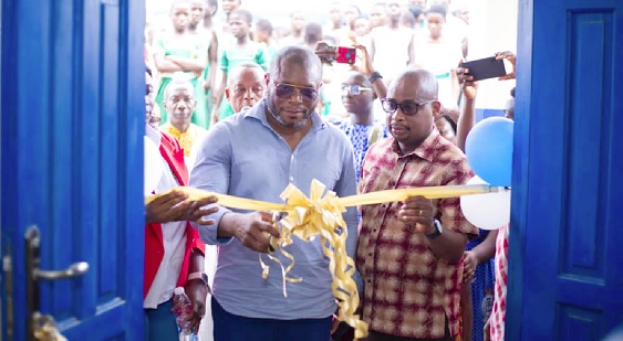 •  Edward Mensah (right), Corporate Social Responsibility Coordinator of Yinson Ghana, being assisted by John Agyare, Executive Committee Chairman of the Ahanta West Municipal Assembly, to open the facility