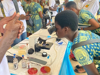 Some of the students at the festival looking through a microscope 