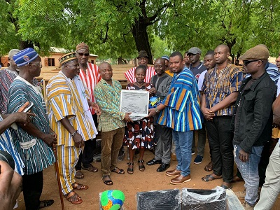 Mr Mathew Silas Amoah (3rd right) handing over a computer monitor to Mr Safianu Yakubu, headteacher of the JHS while staff and other guests look on.