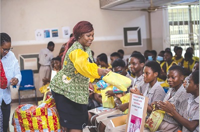 Lucia Addae-Ntiri, President of LAPAG, distributing menstrual hygiene products to schoolgirls within the Ablekuma enclave in Accra 