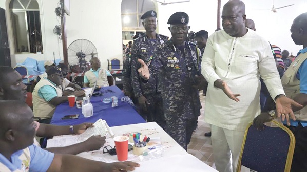Dr Serebour Quaicoe (right), Director of Electoral Service at the EC, ushering Dr George Akuffo Dampare, the Inspector General of Police, to the collation centre at the Kumawu 
