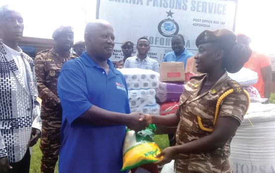 Nicholas Kwasi Sarkodie  (2nd from left), member of the Lutheran Media Ministry Ghana, presenting one of the items to DSP Leticia Ohemeng, an officer of the Koforidua Prisons 