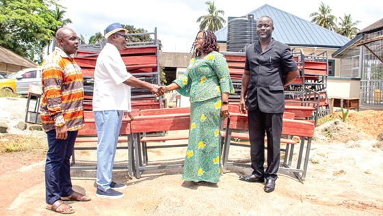 Abdul Munim Issah (2nd from left), the MCE, presenting the desks to Sally Nelly Coleman, Metro Director of Education