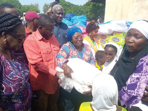 Frema Osei-Opare (arrowed) Chief of Staff, distributing the relief items to the flood victims