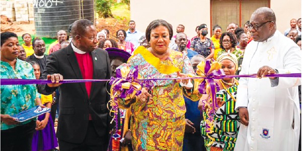 Rebecca Akufo-Addo, First Lady, cutting the tape to open the hostel. With her are Rt Rev. Prof. Joseph Obiri Yeboah Mante (right), Moderator of the General Assembly of the Presbyterian Church of Ghana, and Rev. Ebenezer Acheampong Asiedu (left), Akuapem Presbytery chairperson