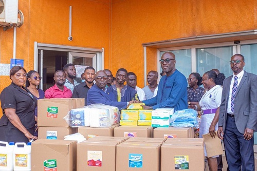Professor Daniel Ansong(5th left), Dean of Medical School,  presenting some PPEs to Professor Okyere Addai Mensah(3rd right), CEO of KATH, while other dignitaries look on.