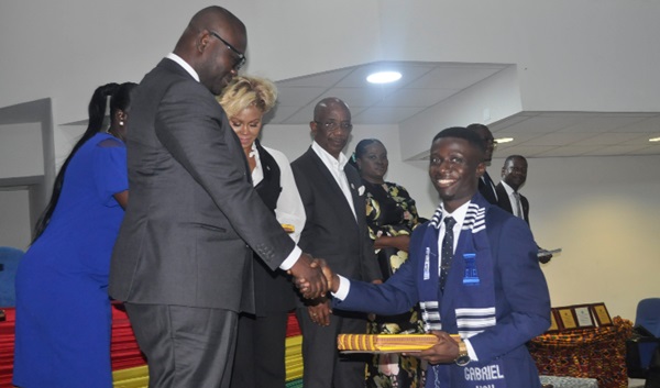 Francis Asenso-Boakye (left) handing over a certificate to Gabriel Yaw Osei, the Overall Best Student