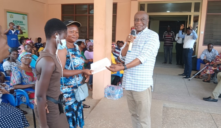 The MCE (right) presenting cheques to some of the beneficiaries