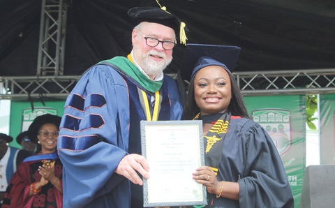 Natalie Osei (right) receiving the Overall Best Bachelor of Medicine and Bachelor of Surgery Graduating Student from Prof. Timothy R. B. Johnson (left), Chief Mentor, Family Health University College, during the ceremony