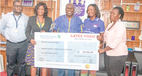 Gifty E. Appiah (2nd from right), Public Relations Officer of Latex Foam, presenting a dummy cheque to Prof. Gordon A. Awandare (middle), Pro-Vice-Chancellor, Academic and Students Affairs of the university. With them are Mawusi Kofi Gloza (left), Senior Assistant Registrar, Office of the Pro-VC; Dr Elizier Taiba Ameyaw-Buronyah (2nd from left), Director of Public Affairs of the university, and Selina Saaka, Head, Students Financial Aid Office