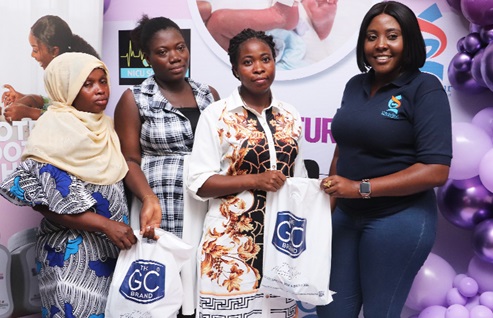 Victoria Abakah, Brand Manager at Ghandour Cosmetics Ltd, presenting gift bags to some mothers at the unit