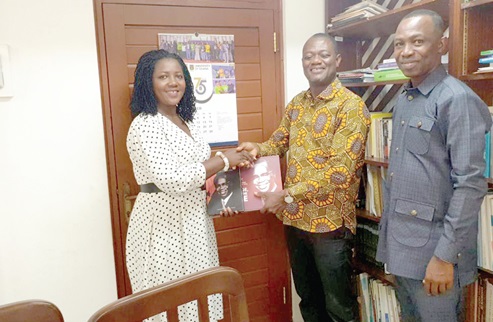 Linda Nyarko (left), an official of BIRDD, presenting Prof. Busia’s biography to Dr Anamzoya. Looking on is Anane Agyei, Executive Director of BIRDD