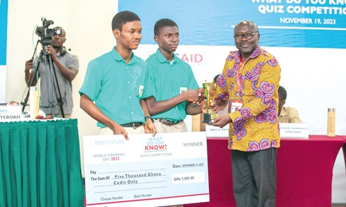 Phinehas Herob Boanerges and John Orleans-Lindsay receive a dummy cheque and trophy from Moses Anim (right), Deputy Minister of Fisheries and Aquaculture Development, after winning the competition