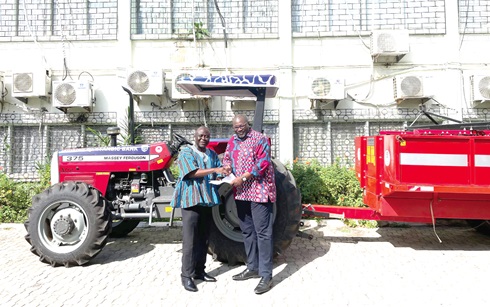 Kojo Larbi (right), Manager for Communications at Stanbic Bank Ghana, presenting documents of the tractor to Yaw Frimpong Addo, the Deputy Minister of Food and Agriculture in charge of Crops 
