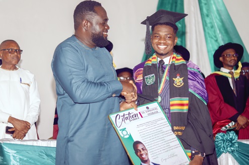 Alex Incoom, who deputised for the Eastern Regional Minister as the guest speaker for the ceremony, presenting a citation to Emmanuel Oyebanji