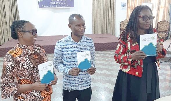 Rhonda Gavor (left), Director in Charge of Human Resources, with George Amoah (middle) and Gloria Botelei, Director Policy, Planning, Monitoring and Evaluation at the Ministry of Employment and Labour Relations, displaying copies of the policy document 