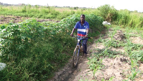 54-year-old Ogbamey Tackie riding a bicycle to his farm at Tuba 
