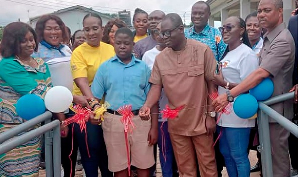 Kwadwo Ayensu Obeng (3rd from right), Deputy ECG Managing Director, being assisted by Doreen-Carol Anning-Gyebi (3rd from right), President of the Power Queens Club, ECG, and Richard Odame (middle), Prefect, Akropong School for the Blind, to cut the tape to inaugurate the facility