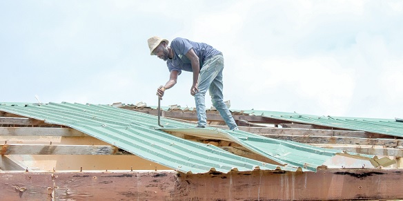 A worker removing the old roofing sheets on Manle Dada school building. Picture: ERNEST KODZI