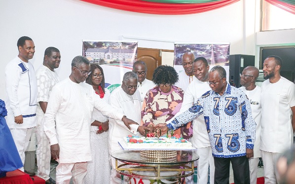 Tina Mensah (middle), a deputy Minister of Health, being assisted by Dr Opoku Ware Ampomah (3rd from right), CEO of Korle Bu, and other heads of department to cut the cake