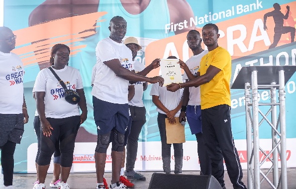 Administrative manager of Ghana Athletics Federation, Boakye Yiadom (right), presenting a certificate of endorsement to the Chairman of DKFC, Benjamin Ahulu