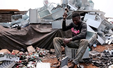 A young man digging through electronic waste for scrap metals is contributing to the menace