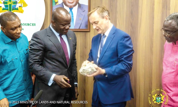 Neil Herbert (right), Chairman of Atlantic Lithium, showing a piece of lithium to Samuel Abu Jinapor (middle), Minister of Lands and Natural Resources, after signing the agreement