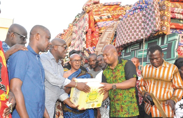 Eric Seddy Kutortse (3rd from left), Executive Chairman of the First Sky Group, presenting the items to Samuel Okudzeto Ablakwa, NDC MP for North Tongu, while Togbe Patamia Dzekley VII (middle), Paramount Chief of Battor, and others look on.  Main Picture: The relief items