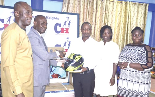 Enock Dery Pufaa (3rd from right), Programmes Director of Challenging Heights, presenting a helmet to  Chief Superintendent Mike Baah (2nd from left), Head of the Anti-Human Trafficking Unit