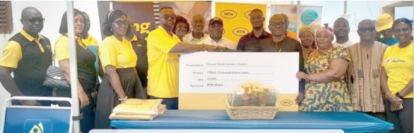 Prince Owusu Nyarko (4th from left) presenting a dummy cheque to Perry Mensah, Chairman of the Afahye Planning Committee. With them are some chiefs and officials of MTN