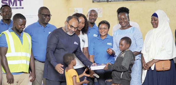 Alex Dutamby (3rd from left), Managing Director, SMT Ghana, and his team presenting the books to the children