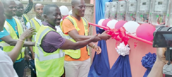 Emmanuel Lumor (right) cutting the tape to mark the official commencement of the project in Cape Coast. With him is Ebenezer Kwakye Sarkwa, Cape Coast District Manager of the ECG