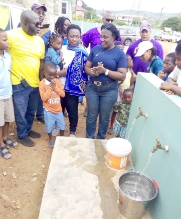 Nana Ama Owusu, Executive Director of Potter’s Village, and others looking on as the water flows
