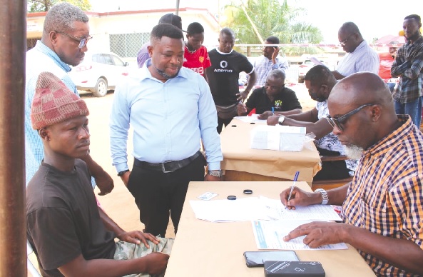 Some guarantors (standing) assisting an eligible voter (seated left) to go through the registration process. Picture: DELLA RUSSEL OCLOO