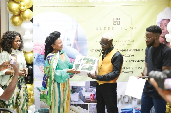 Dr Nora Bannerman (middle), CEO of Sleek Garments Export Limited, presenting one of the products to Nana Kwame Ankumah, the Brand Ambassador, while Natasha Bannerman-Kudjaw, Chief Operating Officer of Sleek Garments Export Limited, looks on