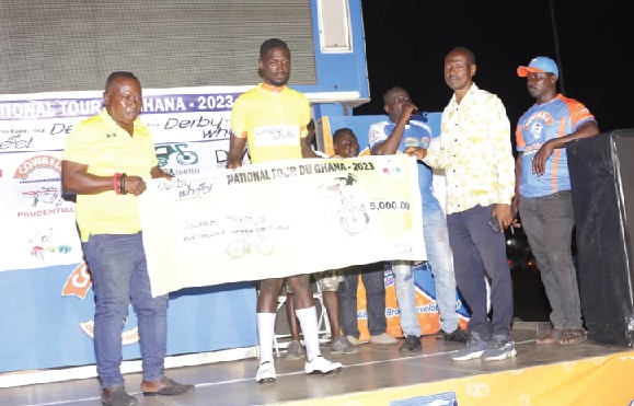 • Solomon Tagoe (middle) receiving a dummy cheque from Shaaban Mohammed and Nii Mankattah (left), officials of the Ghana Cycling Association, after the competition