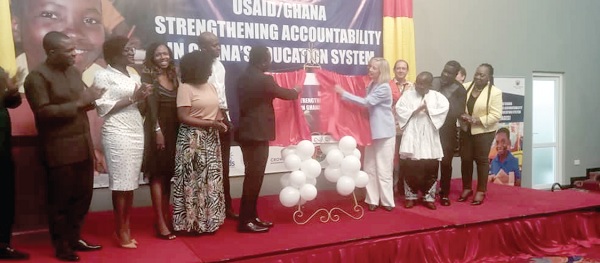 Rev. John Ntim Fordjour (in suit), being assisted by Kimberly Rosen (2nd from right), USAID Ghana Mission Director, to launch the project