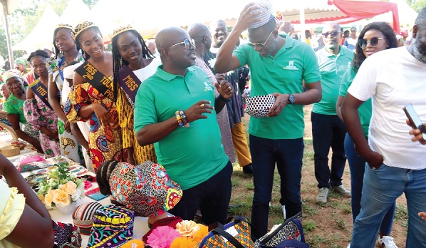 Mark Okraku-Mantey (right), Deputy Minister of Tourism, Arts and Culture, trying on one of the products made by the youth of Ada during the World Tourism Day Celebration. With him is Akwasi Agyeman (2nd from right), CEO, Ghana Tourism Authority. Picture: ELVIS NII NOI DOWUONA
