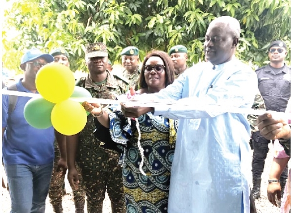Naana Eyiah (middle), Deputy Minister for the Interior, being assisted by Dr Hafiz Bin Salih, Upper East Regional Minister, to cut the tape to commission the border post