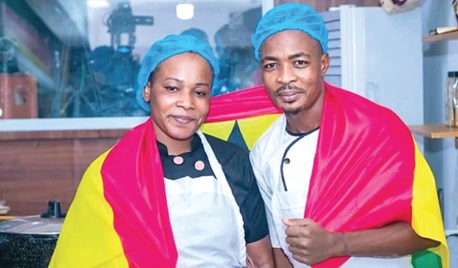 Chef Failatu and Chef Malik Eric, her kitchen assistant, beaming with smiles in the kitchen