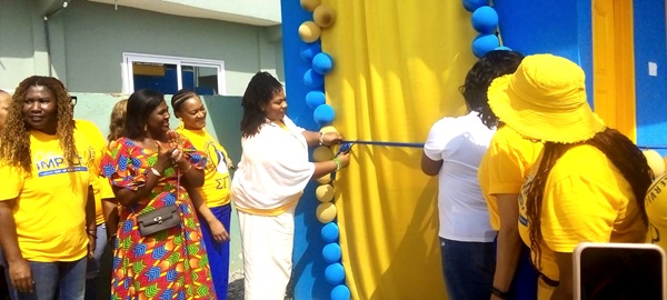 Rasheeda S. Liberty (2nd from right), leader of the delgation, being assisted to cut the tape to inaugurate the toilet facility for the home