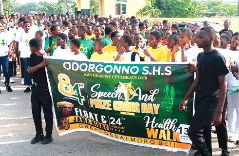 The students holding a banner of the school during the walk 