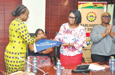 Dr  Dorothy Siaw-Asamoah (left) receiving a gift from Effia Tenge,  Director, Public Engagement of Parliament,  on behalf of the Parliamentary Service Board