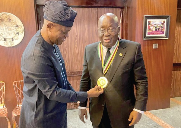 Dr Wale Okediran (left) decorating President Nana Addo Dankwa Akufo-Addo with PAWA’s medal of the Grand Patron of The Arts