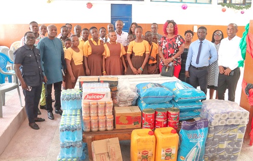 Benjamin Arthur (right), CEO of Fair Wages and Salaries Commission,  with Frederick Tetteh (2nd from right), headmaster of Dzorwulu Special School, some teachers and students of the school as well as some members of staff of FWSC during the presentation ceremony