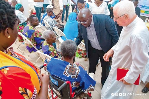 Dr Mahamudu Bawumia (2nd from right) with Rev. Fr Andrew Campbell, Chairman of the Lepers Aid Committee, interacting with some of the cured lepers at the ceremony