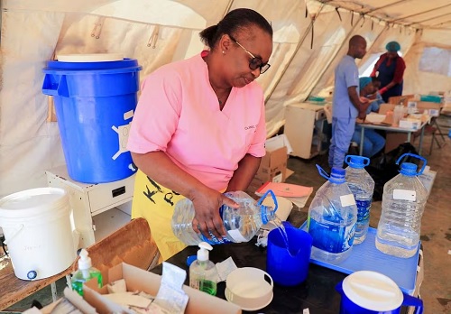 A health worker prepares a solution inside a tent for cholera patients at Kuwadzana Polyclinic in Harare.