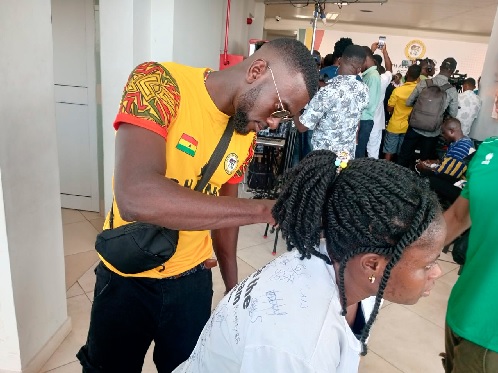 Nana Adwoa Kwofi getting her shirt autographed by Ghana’s 200m gold medallist Joe Paul Amoah